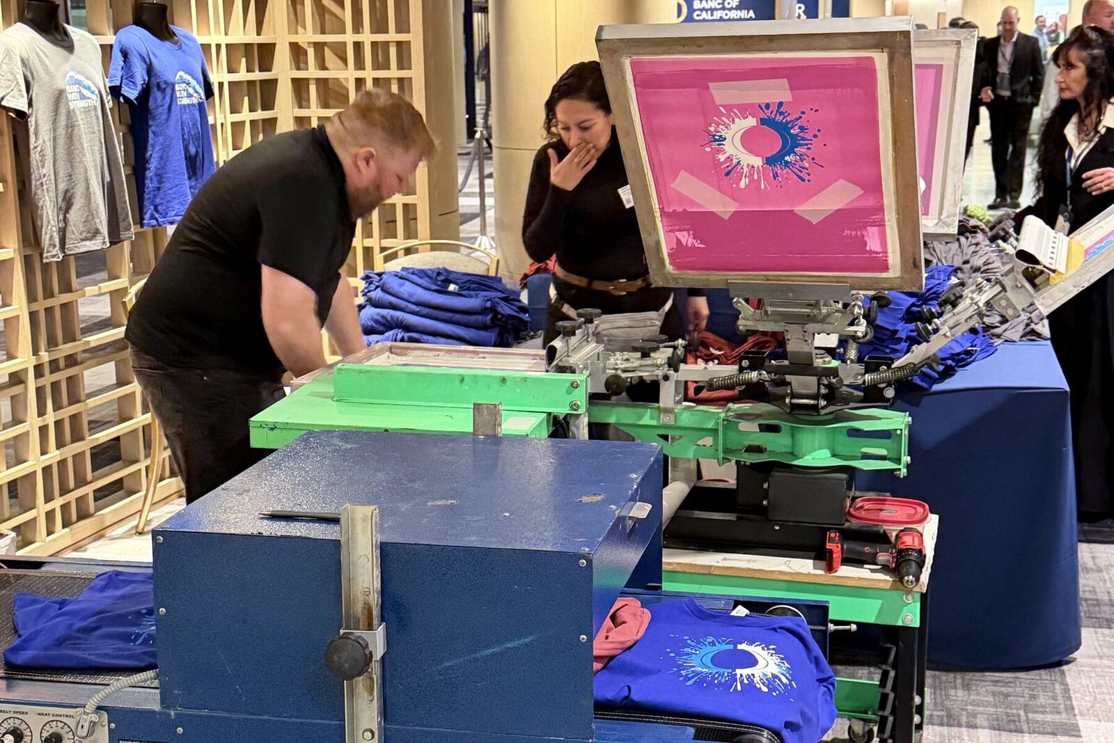 Live garment printing station running inside a corporate conference lobby